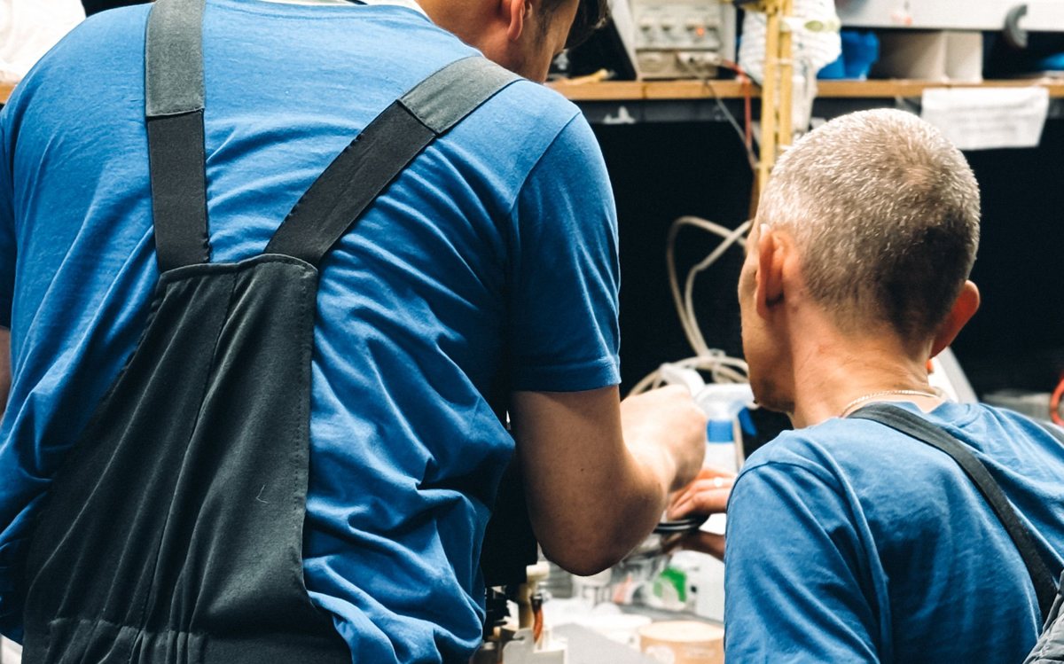 Twee monteurs aan het werk in een werkplaats.