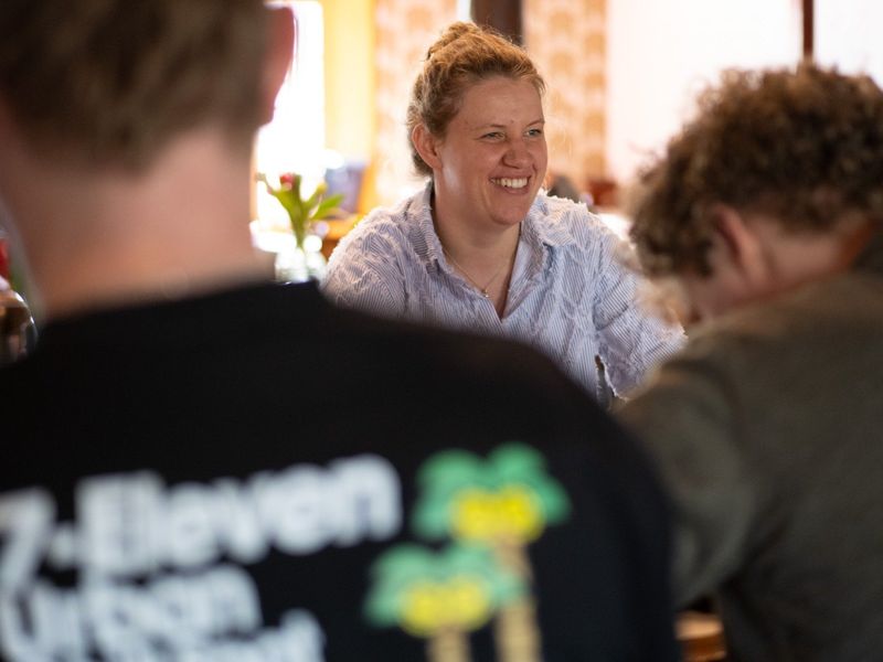 Een lachende deelnemer aan tafel tijdens een training.